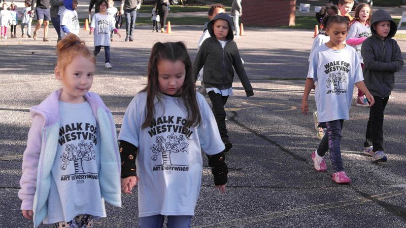 Young students walking together with matching shirts reading "Walk for Westview"