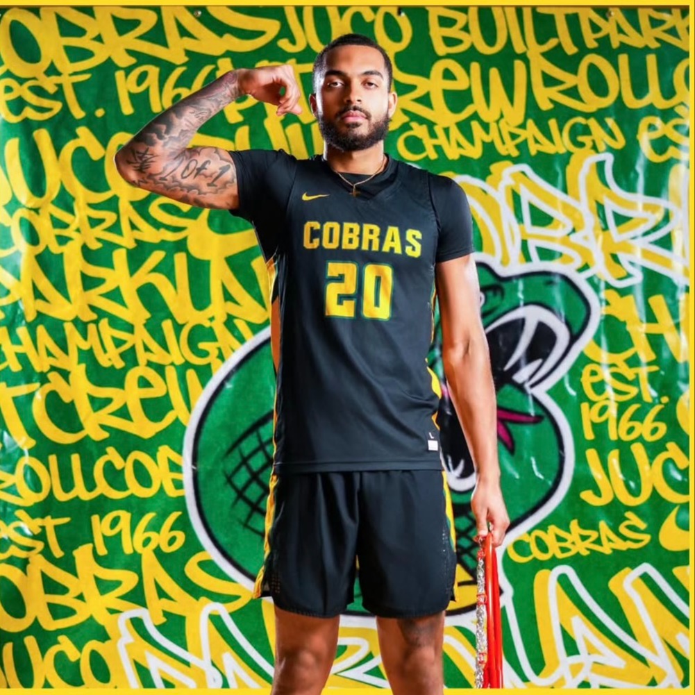 A man in a black uniform with yellow lettering, including the word "COBRAS" and the number 20, stands against a green and yellow background.
