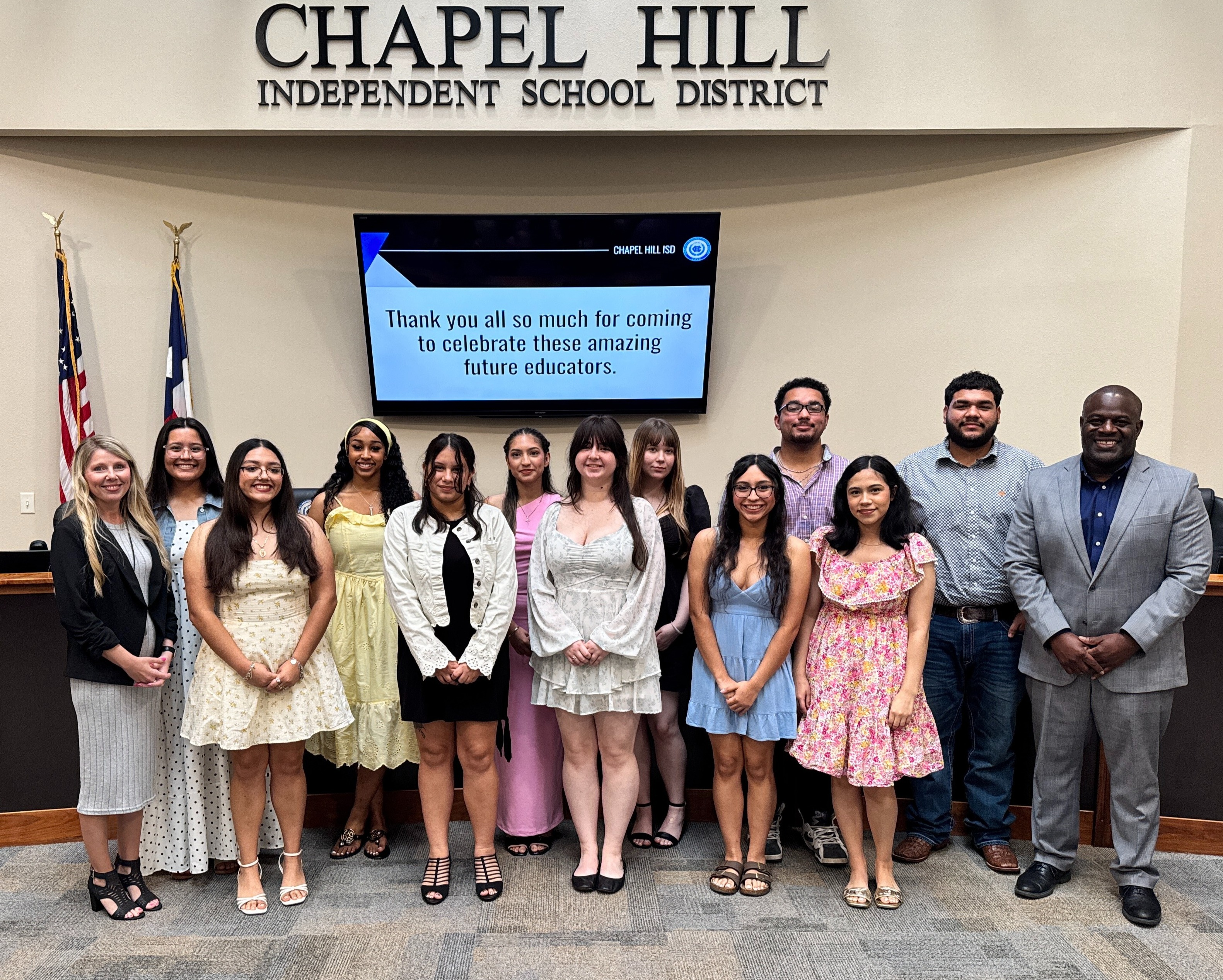 A group of CHISD students stand in the CHISD board room with Superintendent Dean.