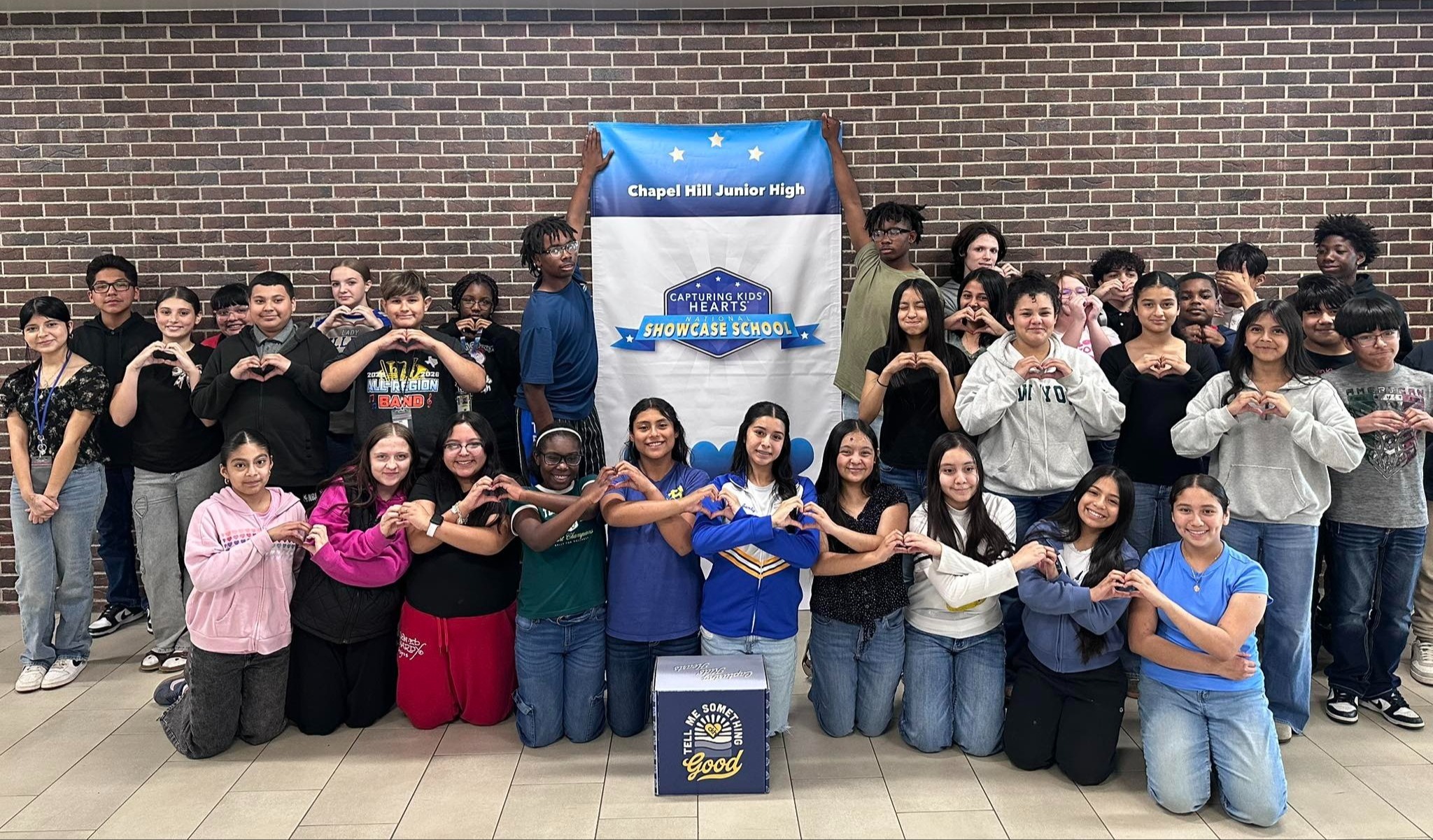 Chapel Hill Junior High students celebrate that their campus is a Capturing Kids' Hearts Showcase campus with a banner.