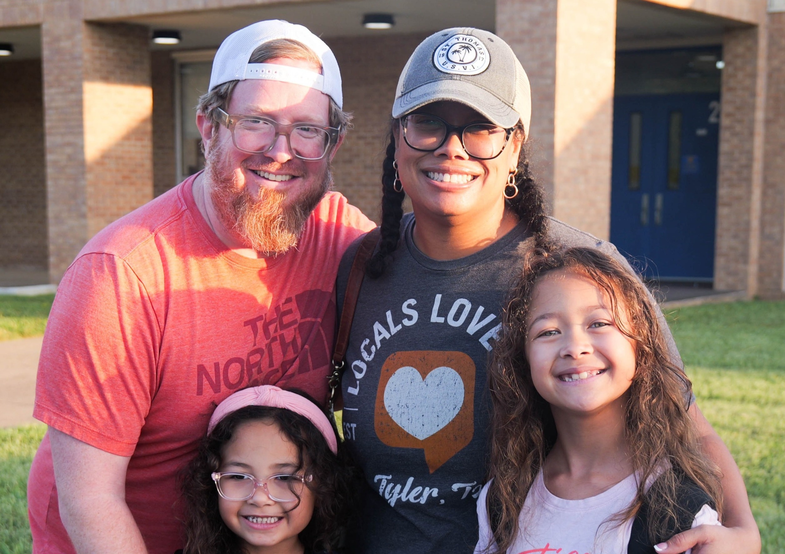 a family stands in front of Wise Elementary on the first day of school