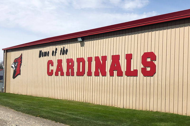 side of school building with Home of the cardinals written on side