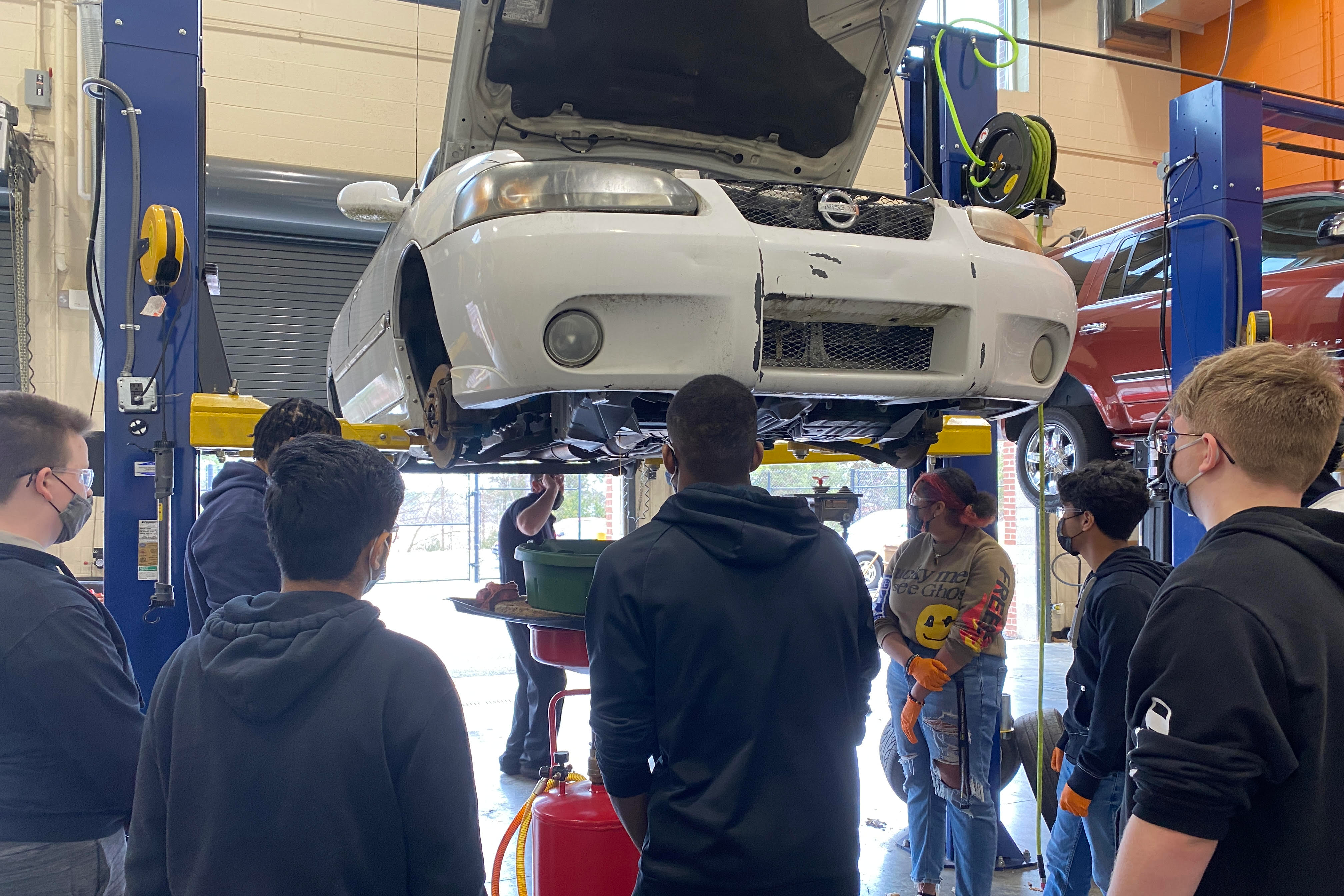 Students working on a car in a garage 