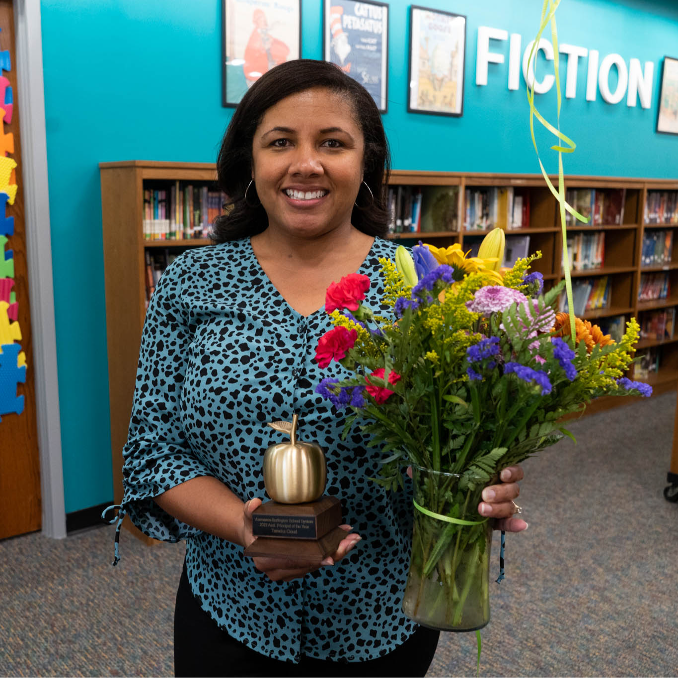 Assistant Principal of the Year - Tameka Cloud holding golden apply trophy and flowers 