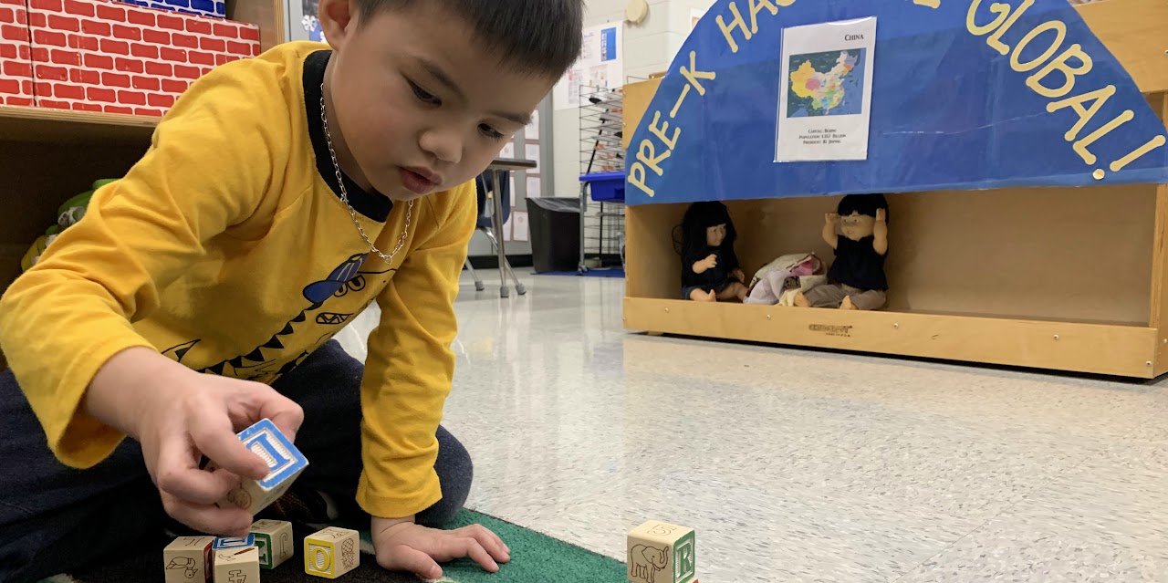 Young boy playing with blocks on a classroom floor