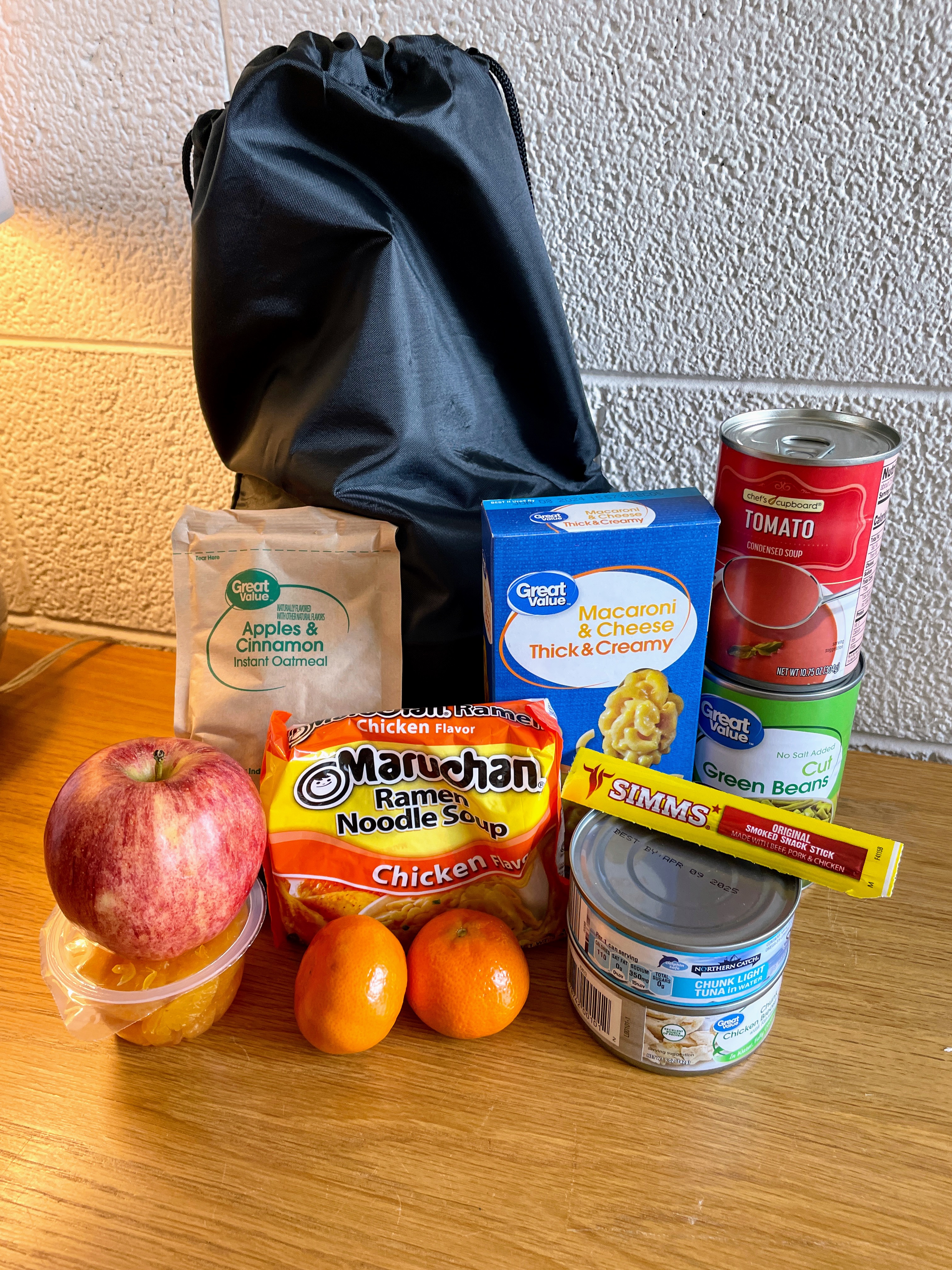 Sample of food items in some schools’ weekly backpack programs with apples, ramen, and canned goods