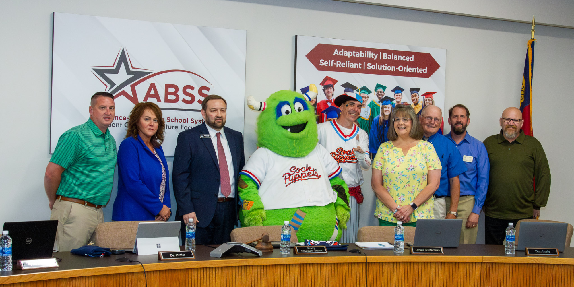 ABSS Board of Education stands with Sock Puppets baseball mascots Whiff and Socksquatch