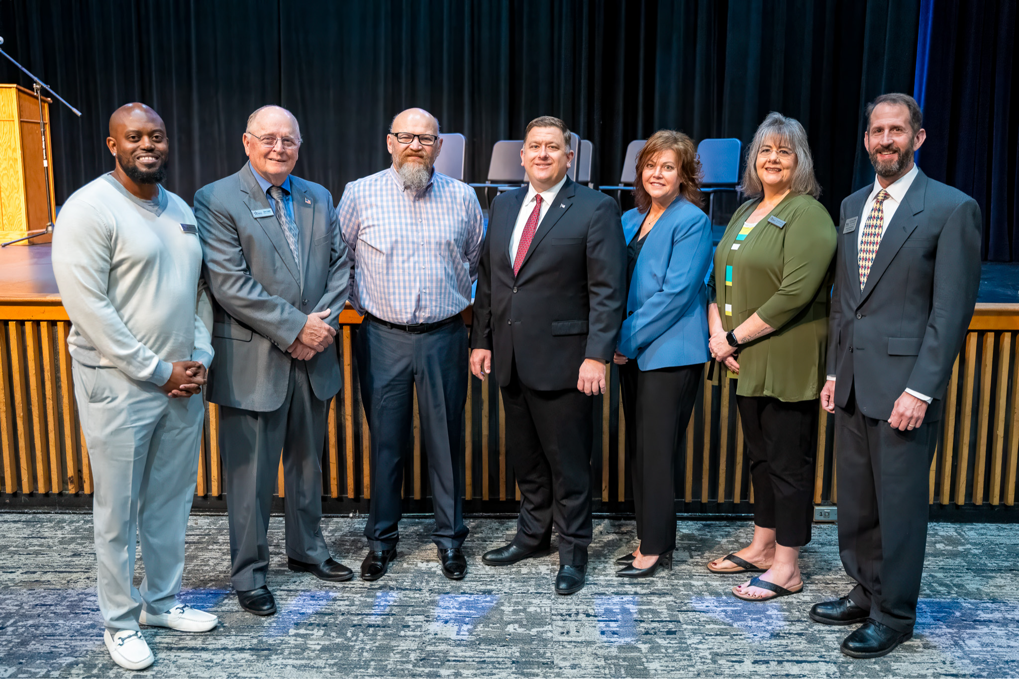 Board of Education with Superintendent Aaron Fleming in front of the stage at Broadview Middle School