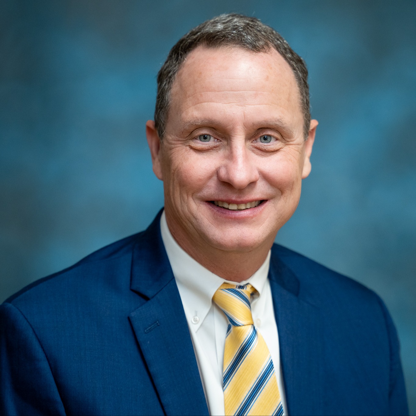 Portrait of ABSS Board Member Avery Wagoner wearing a blue suit