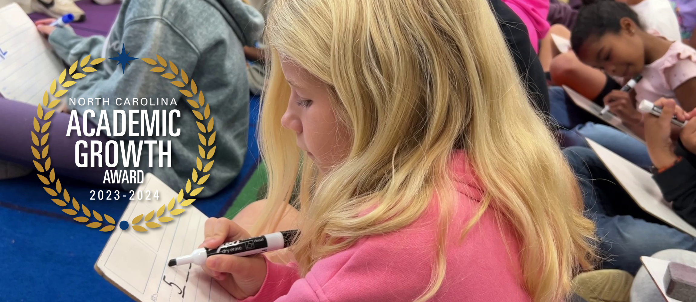 A student doing math on a small whiteboard with overlaid Academic Growth Award medallion