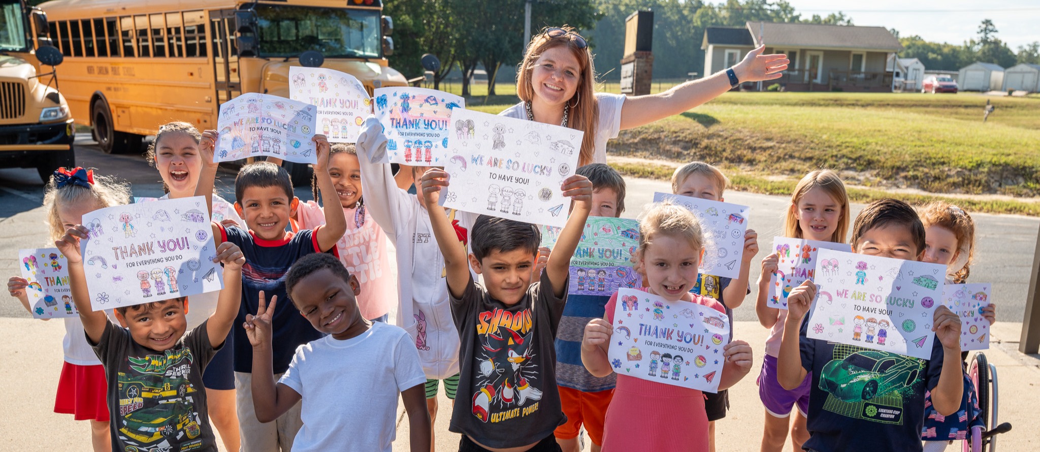 An elementary class holds up Thank You signs during a Hero Day Parade