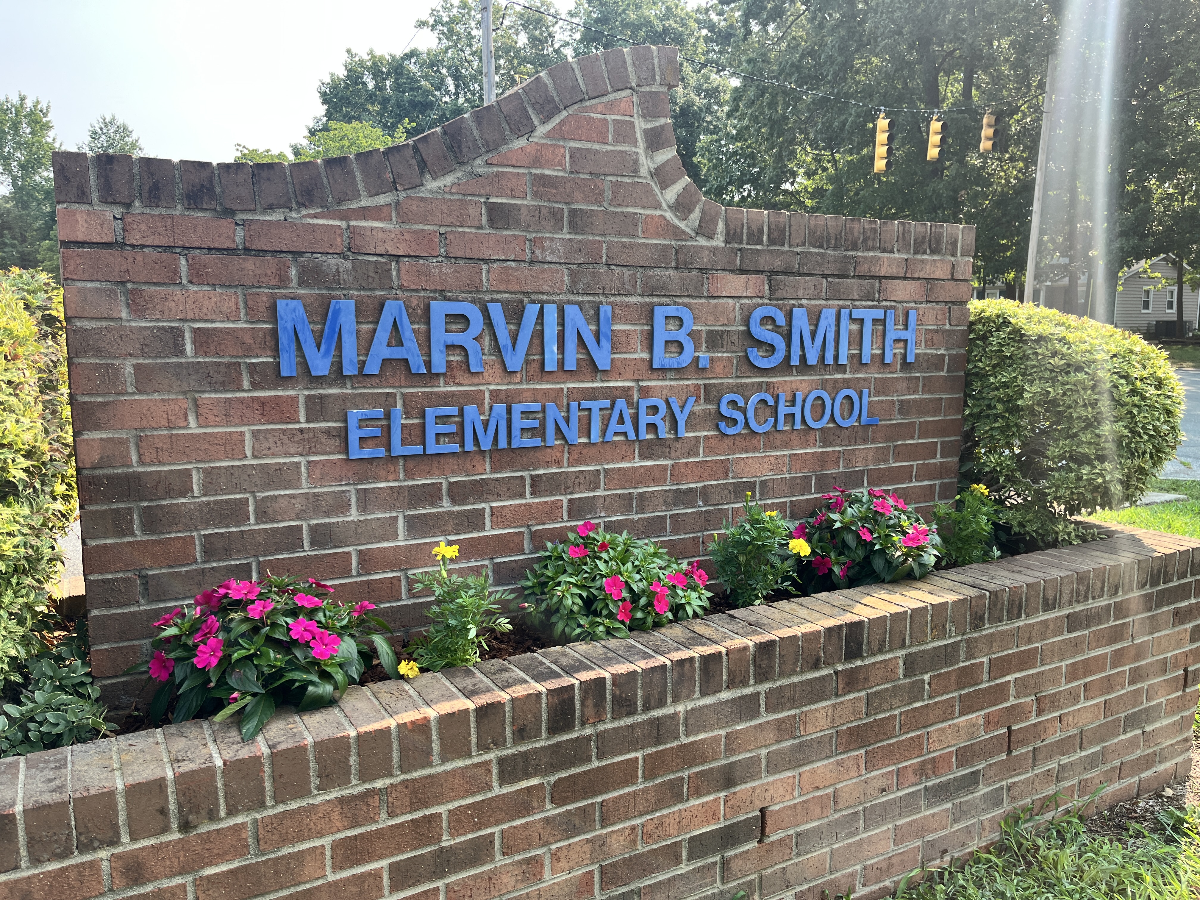 This is a school sign of Marvin B. Smith Elementary School with flowers in front of it. 