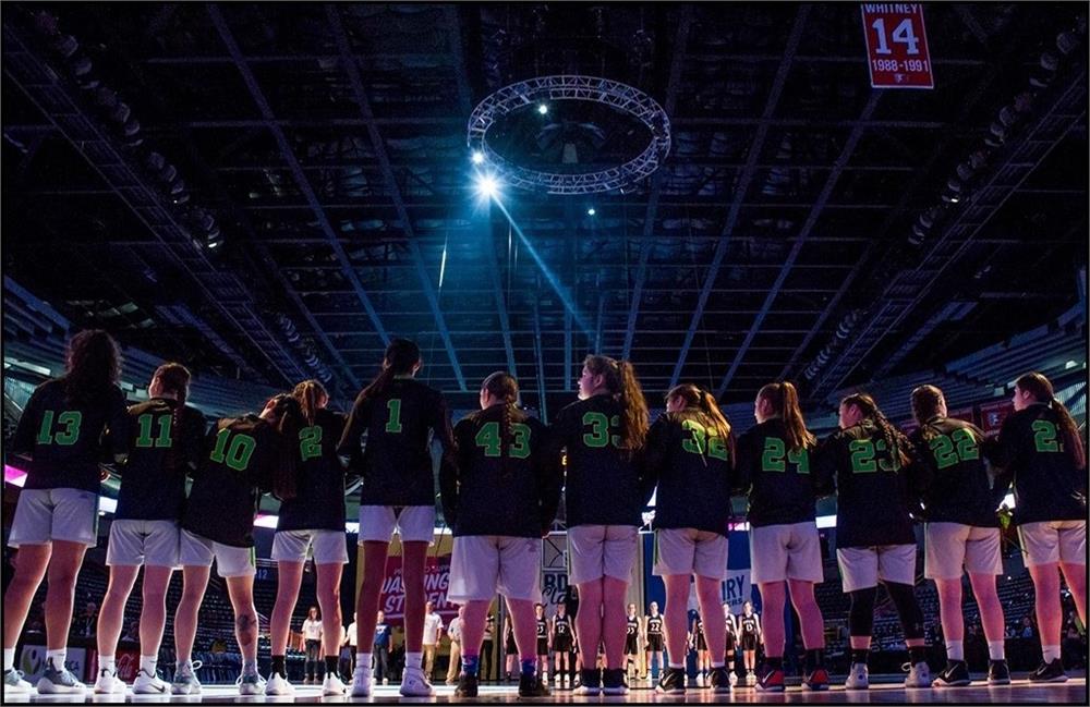 Girls basketball team lined up during the national anthem 