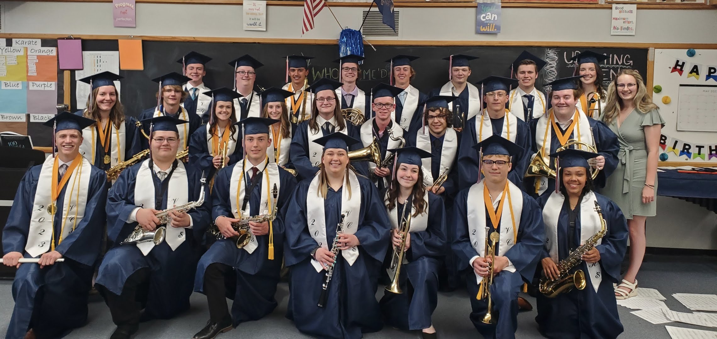 photo of students in graduation gown holding instruments