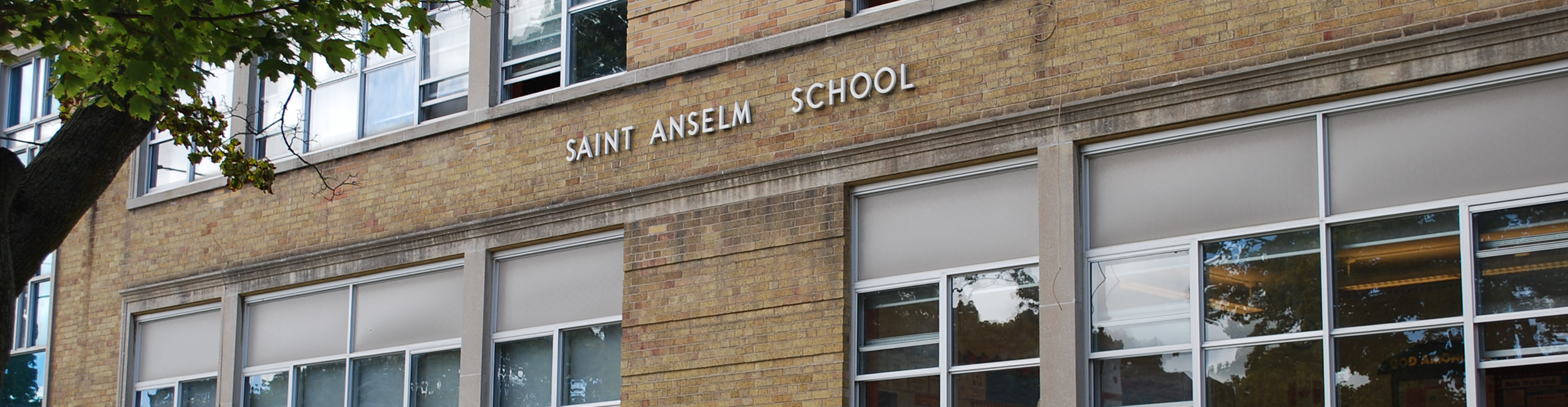 An image of the front of the school building with "Saint Anselm School" written on it.