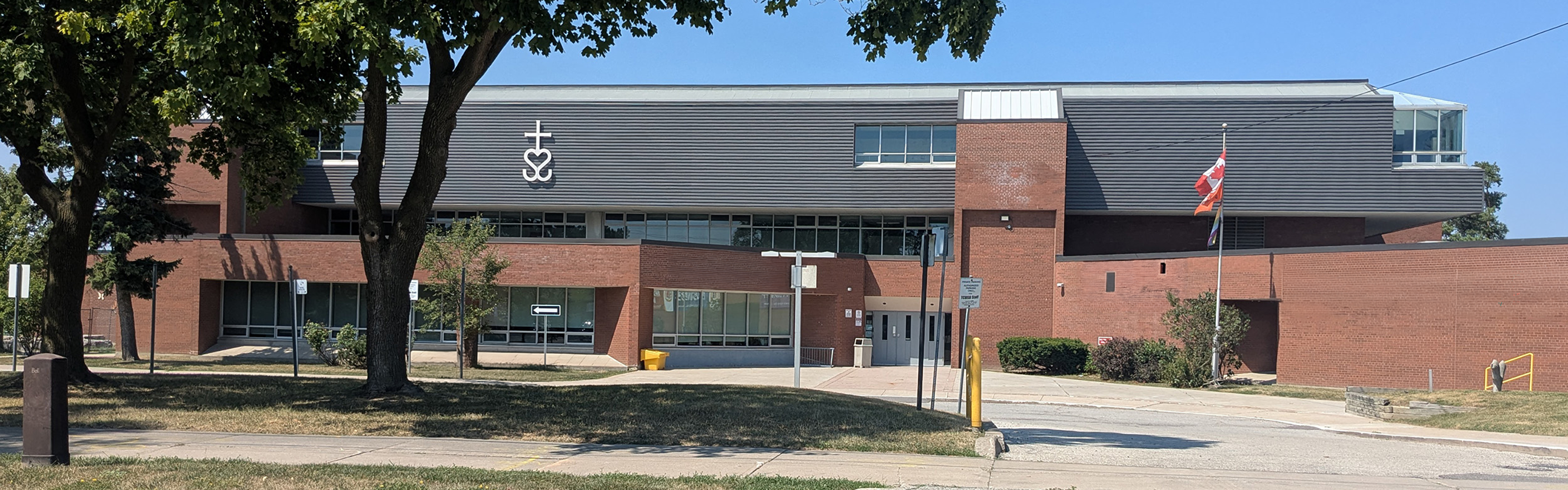 Photo of the temporary Bishop Allen school building, showing a red brick building with black adornments