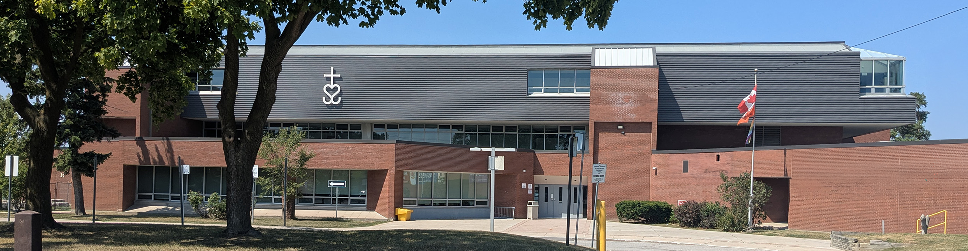 Photo of the temporary Bishop Allen school building, showing a red brick building with black adornments