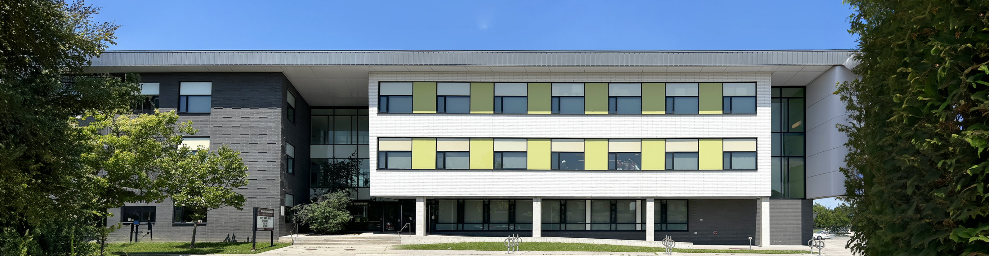 Left, elementary students in white and navy school uniform. Right, the front of the Blessed Pier Giorgio Frassati school building.