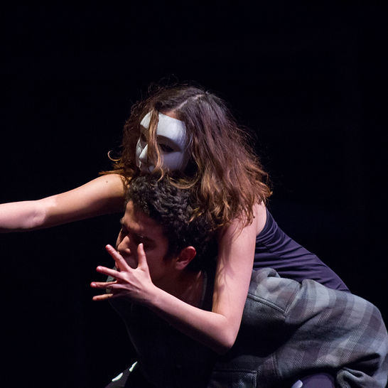 A female student in mask acting on stage. 