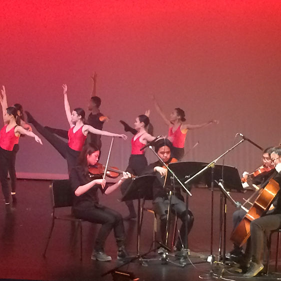 A group of students playing string instruments in a concert. 
