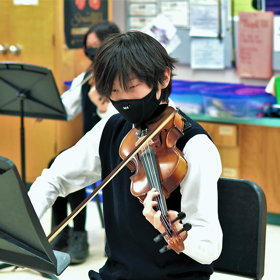 A male student playing a violin. 