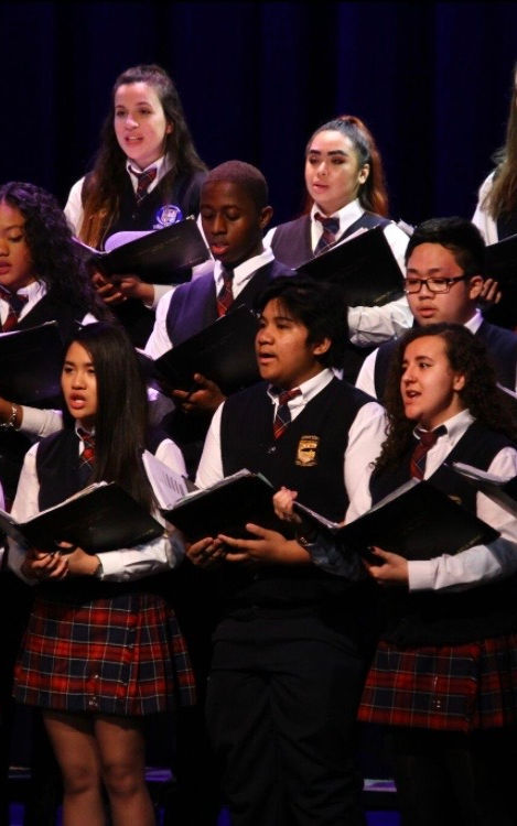 A group of students singing in a concert.