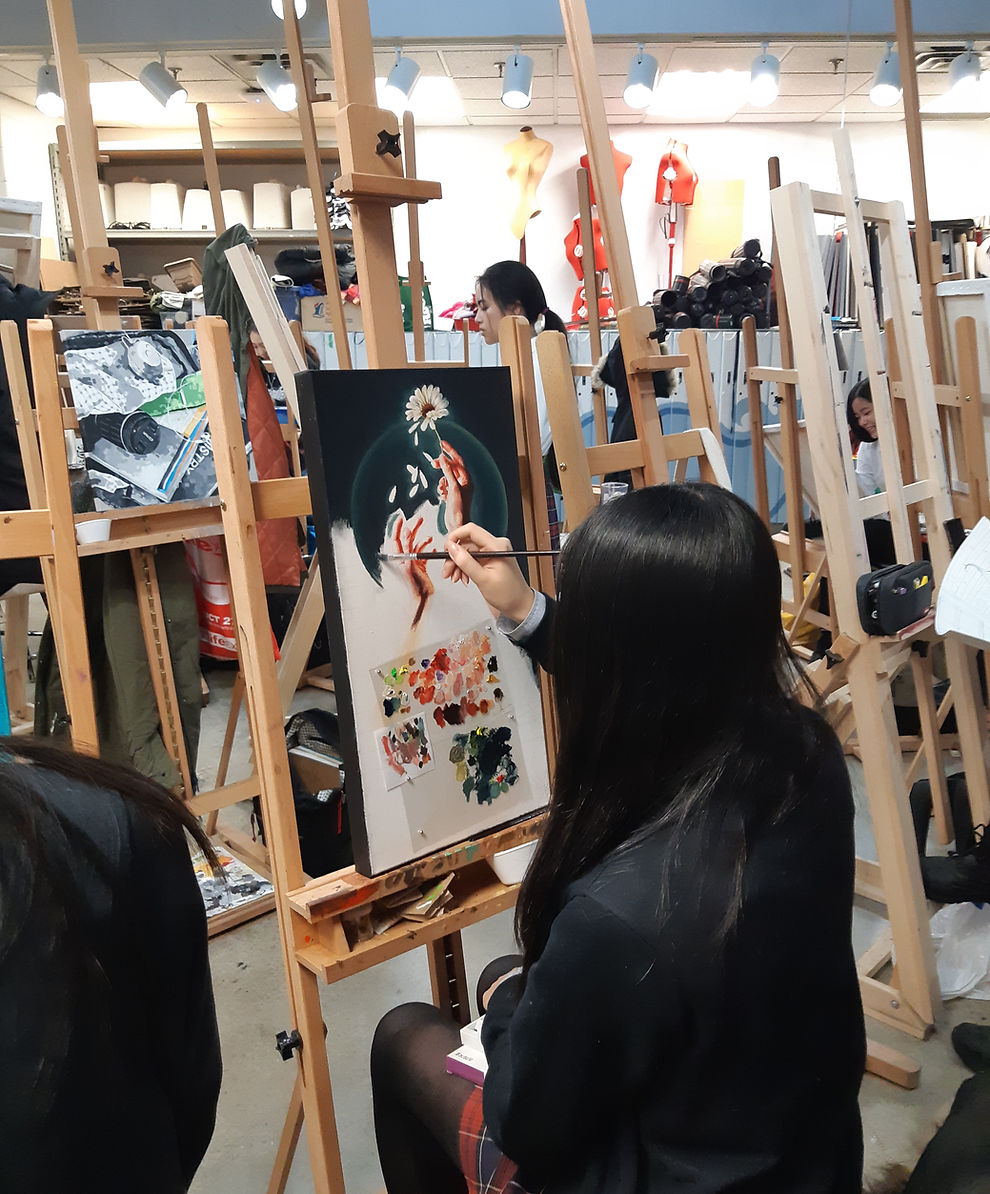 A student painting in a classroom.