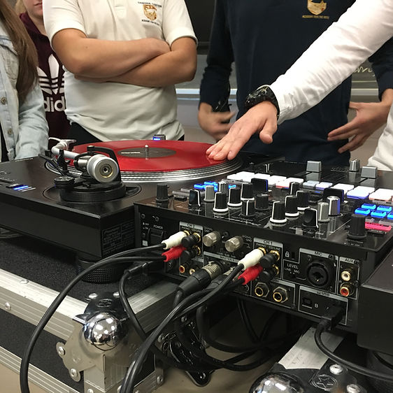 A student learning how to use a music turn table.