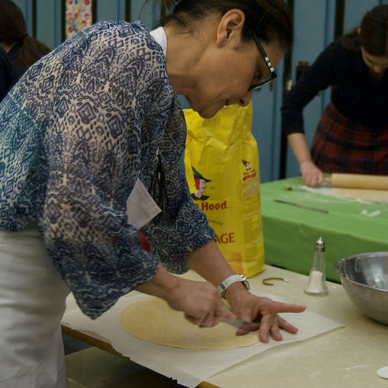 A teacher is making food in a room.