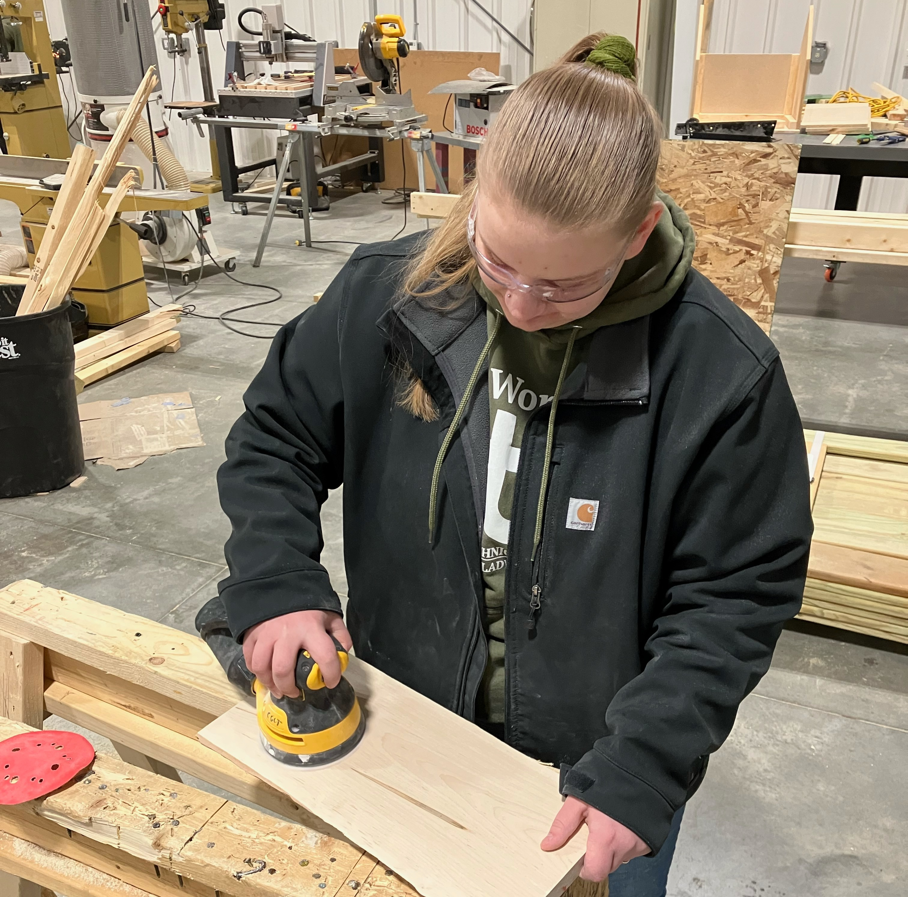 Female Construction student sanding board