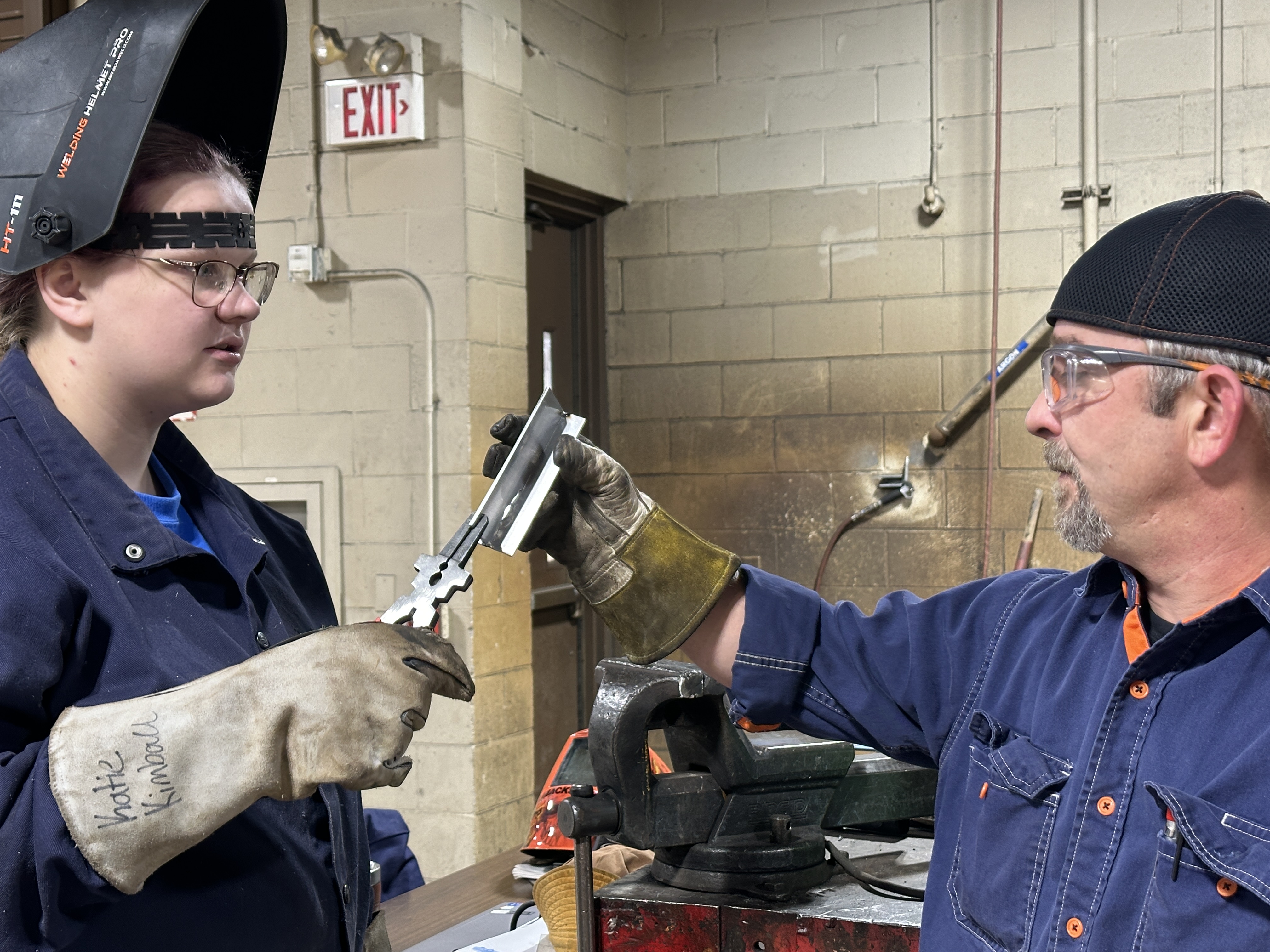 Instructor helping welding student