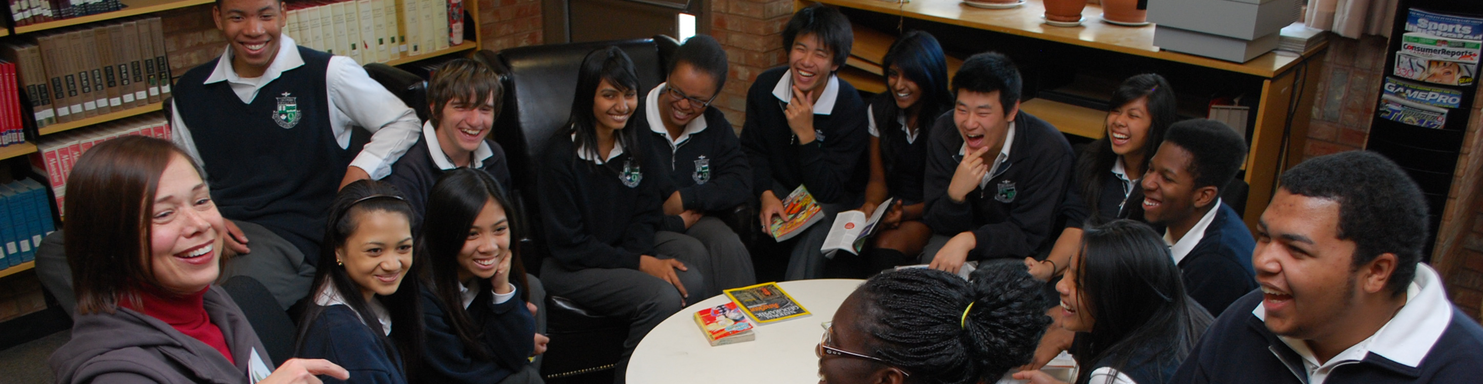 Group of Francis Libermann students in uniform sitting in a circle around the library, in a discussion with the librarian.