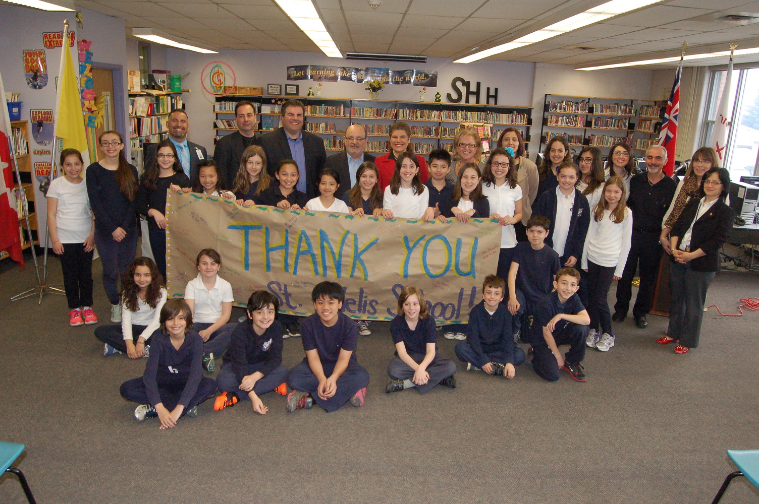 Students and staff holding up a "Thak You" banner in the library