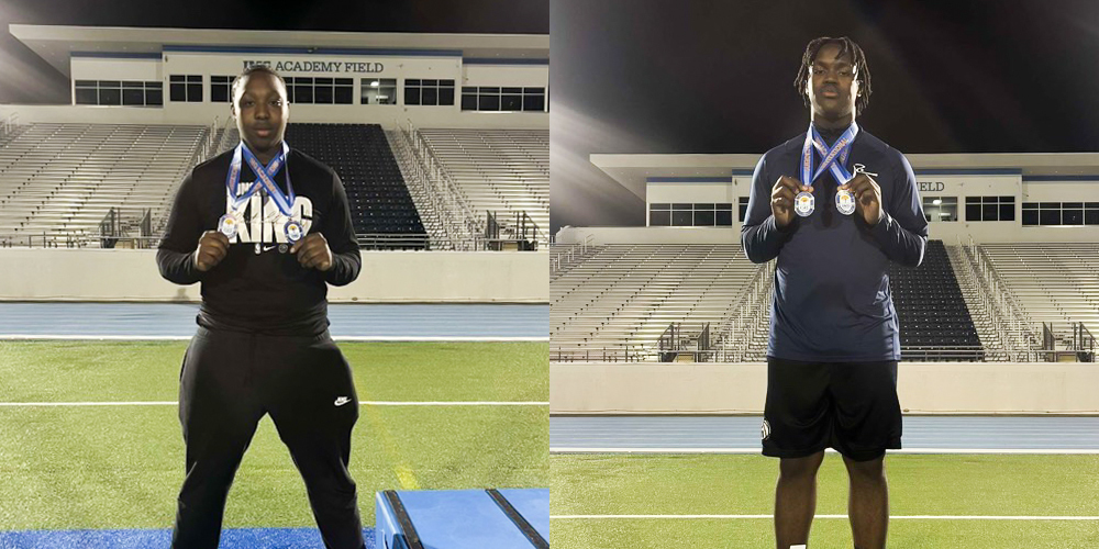 2 students posing with medals on a track field