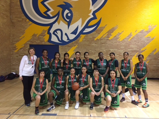 Basketball team in uniform with their championship medals