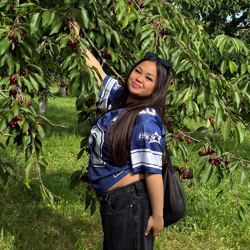 Photo of Samantha picking fruit from a tree