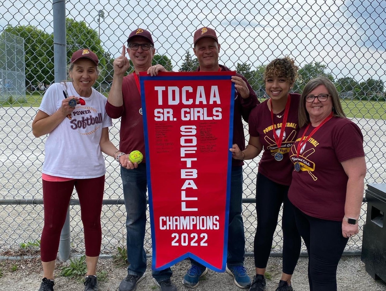 Girls softball coaches with championship banner