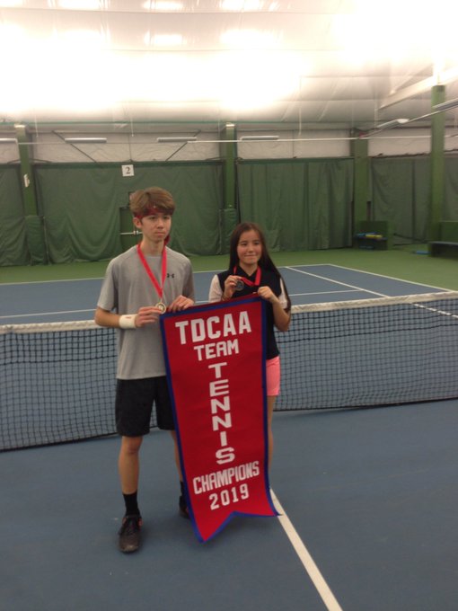 Tennis team players holding championship banner