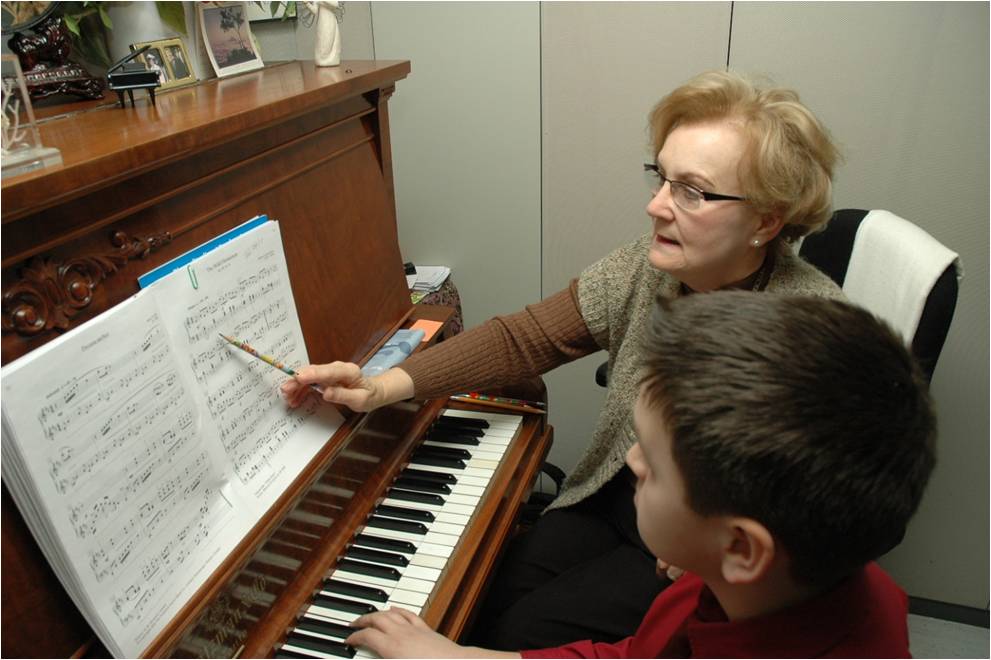 Student and teacher learning piano.