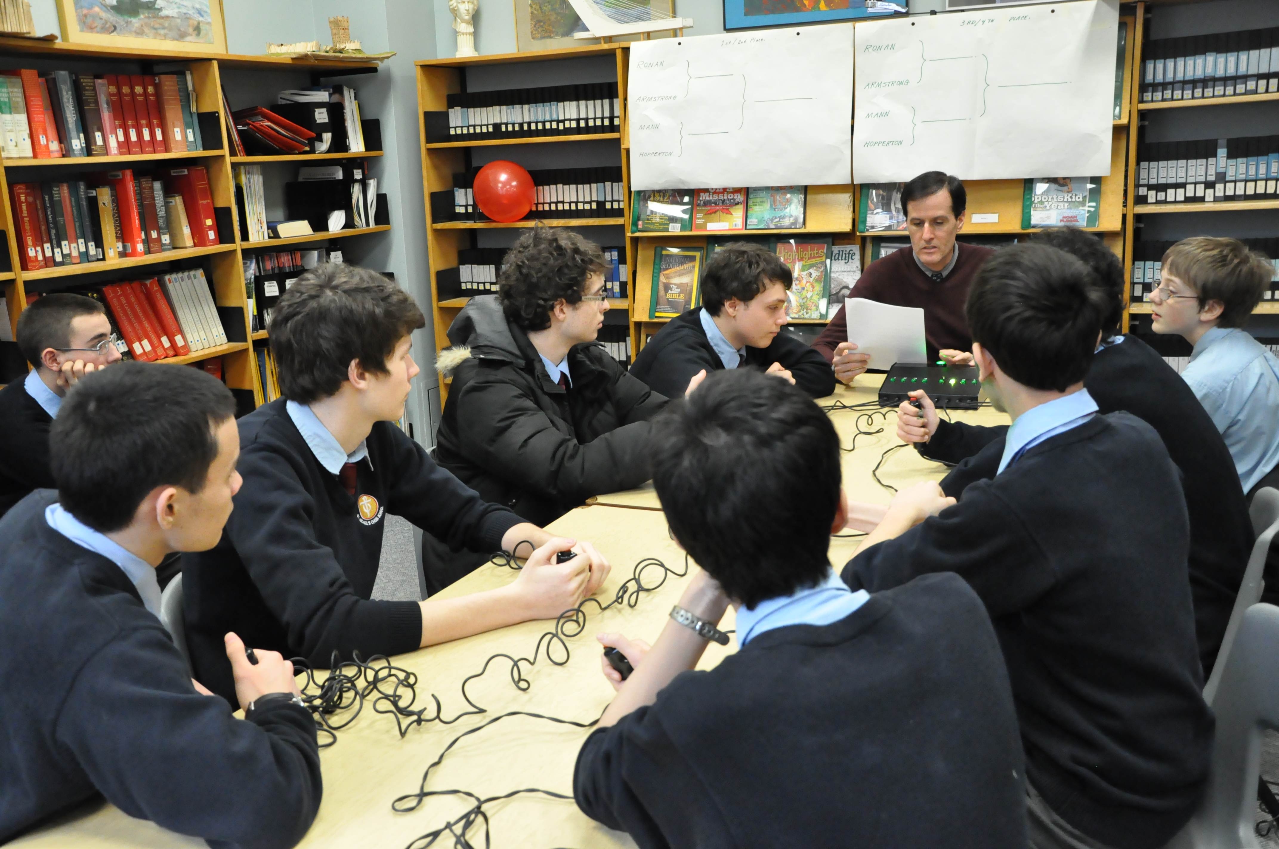 Students around a table with a teacher.