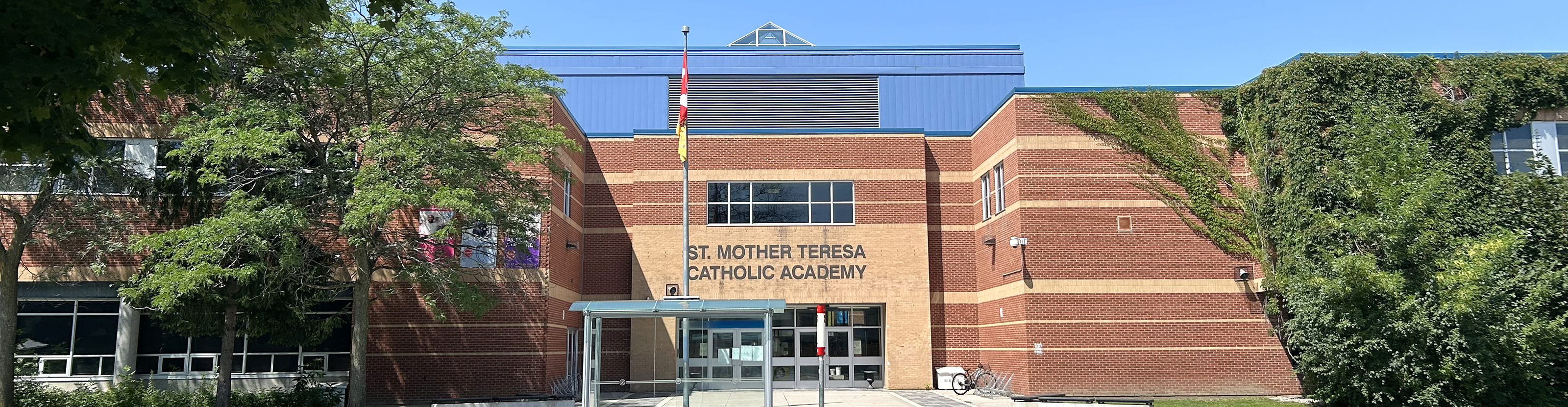 The inside hall of St. Mother Teresa Catholic Academy with many paintings hanging on the walls.