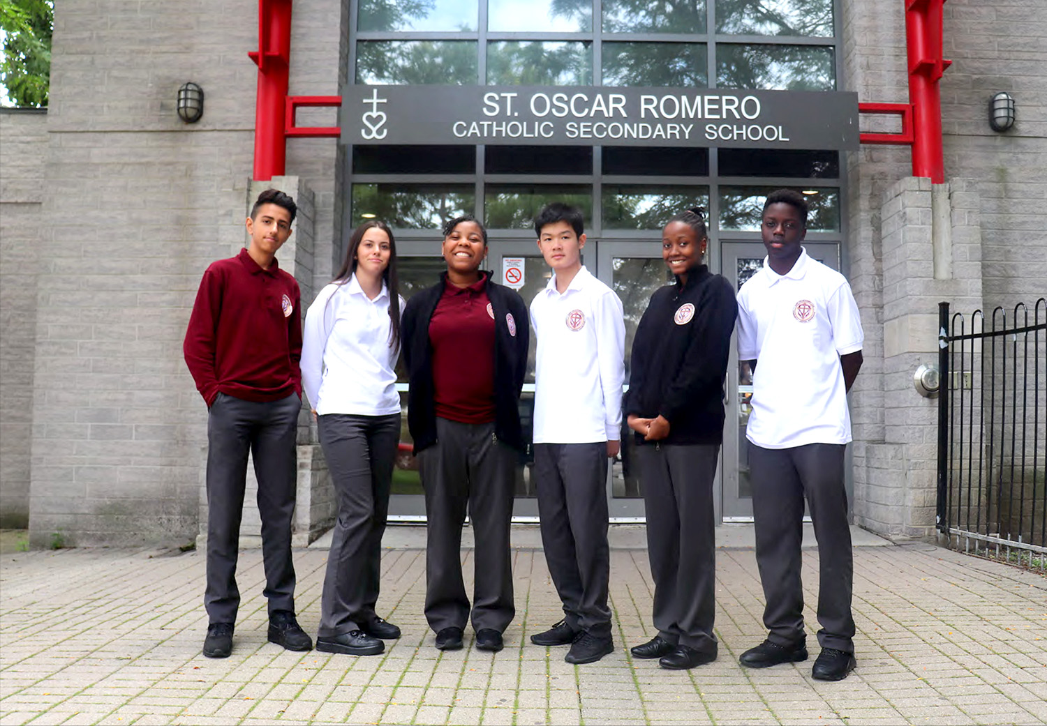Photo of six St. Oscar Romero students wearing different versions of the school uniform
