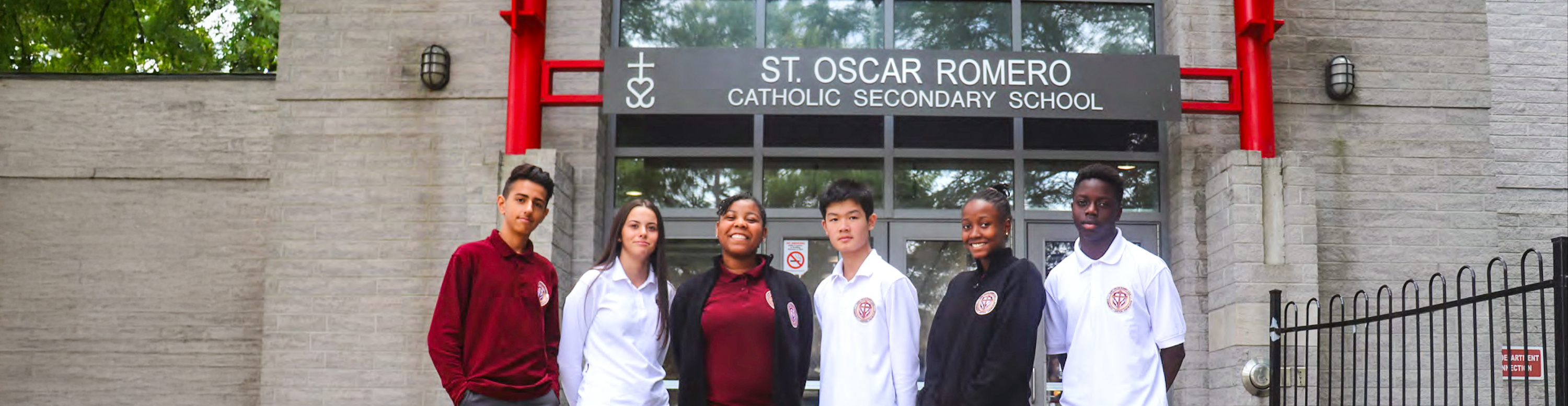 Photo of six St. Oscar Romero students wearing different versions of the school uniform