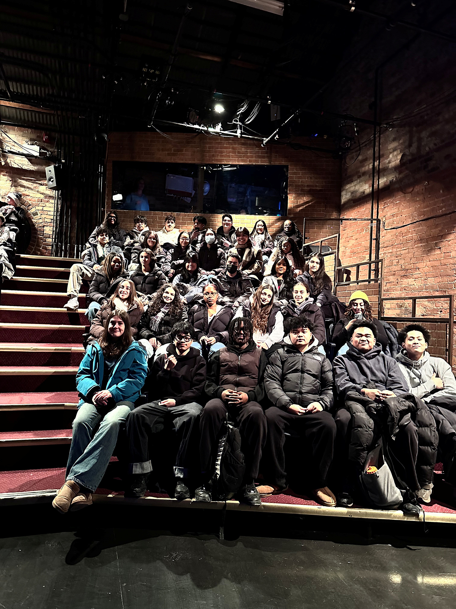 Photo of students sitting together in theatre seats during a theatre outing