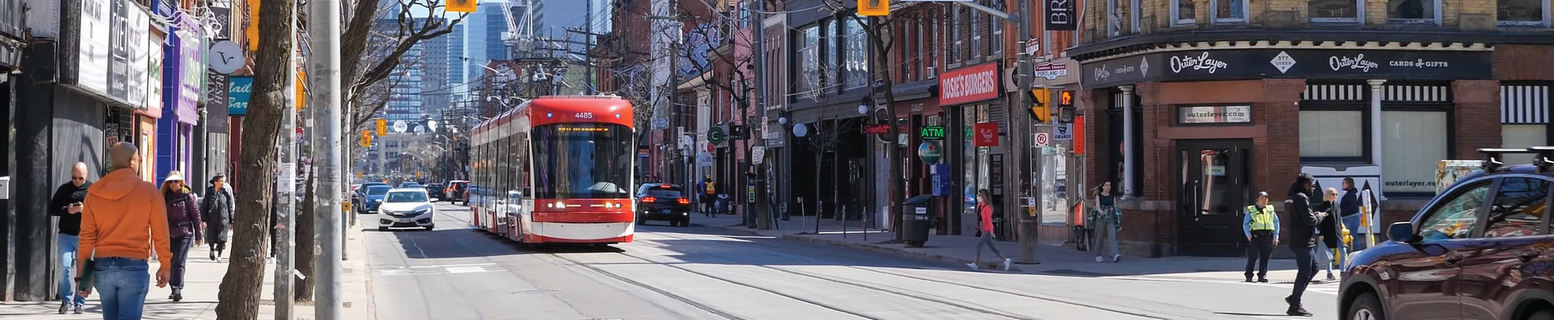 A trolley bus on a busy city street.