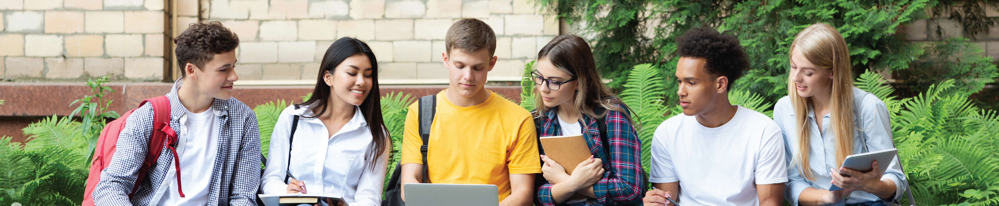 Six students focused around a laptop computer.