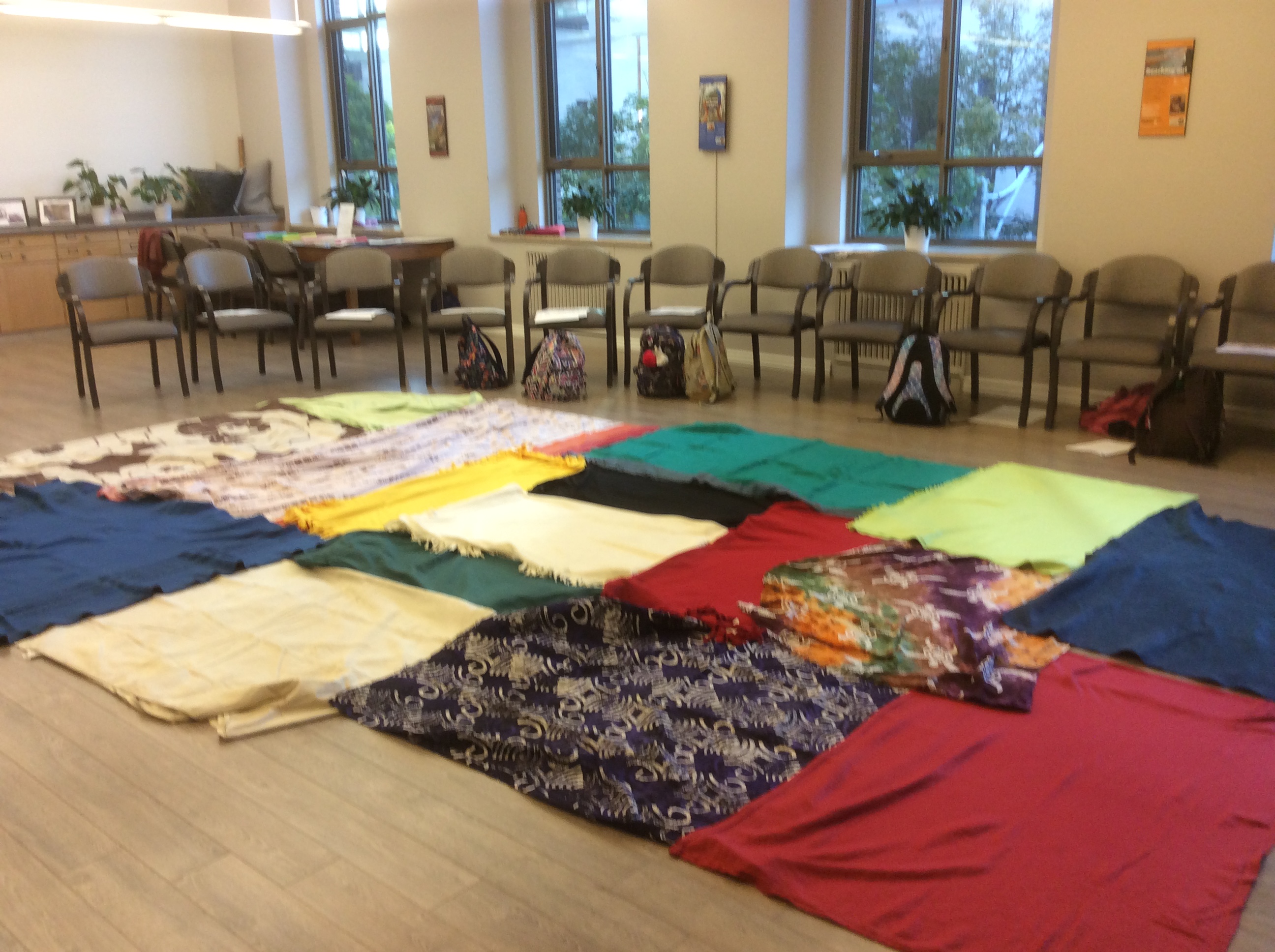 The beginning of The Kairos Blanket Exercise.  The participants sit in a circle with blankets placed on the floor in the centre.  Students from St. Joseph's College Wellesley are participating in learning with Elder Bob Phillips outside.