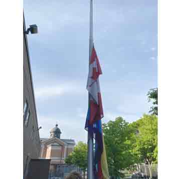 A flagpole with the Canadian flag and Pride flag