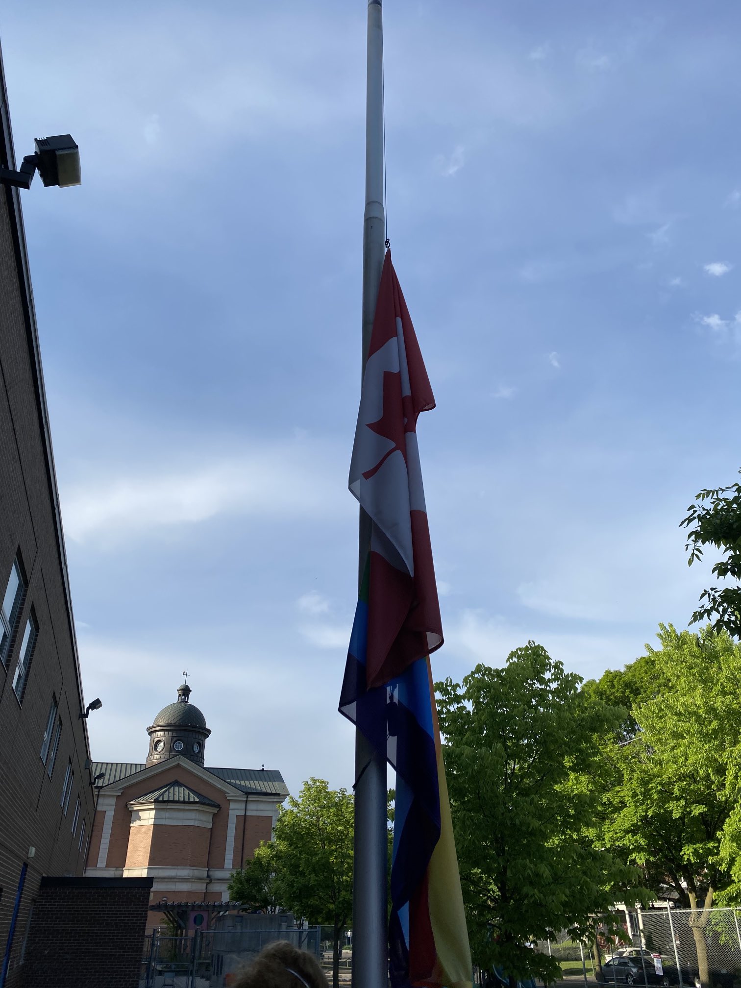 Holy Family Catholic School Pride Flag on Pole with Canadian Flag.