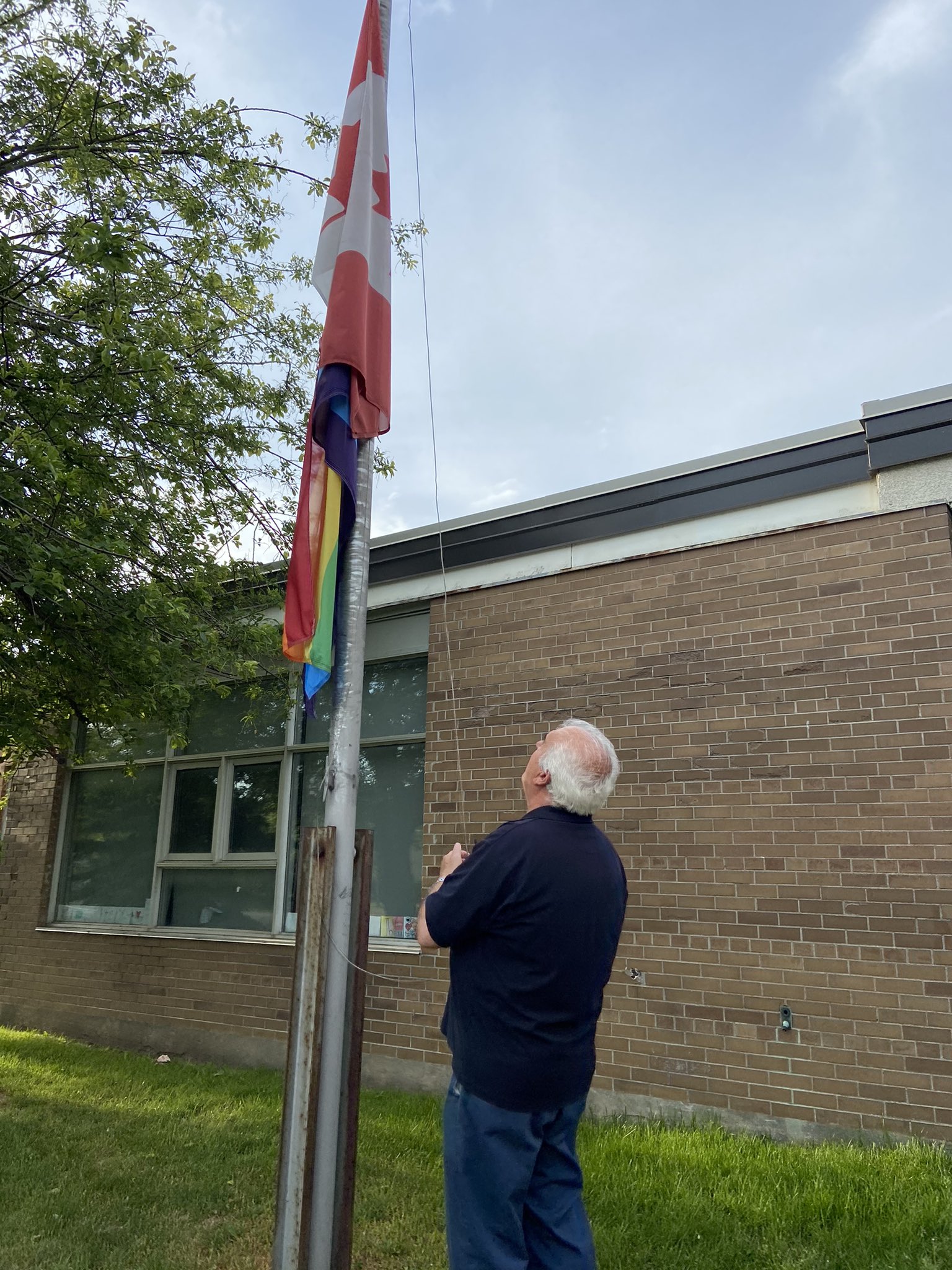 Custodian at the Holy Angels Catholic School Raising the Pride Flag